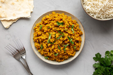 Homemade Red Lentil Dahl with Rice and Cilantro on a gray background, top view. Flat lay, overhead, from above.