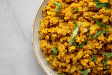 Homemade Red Lentil Dahl with Rice and Cilantro on a gray background, top view. Flat lay, overhead, from above. Copy space.