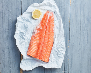 Raw salmon fillet lying on piece of paper