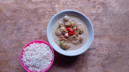 Sayur nangka is Indonesia vegetable soup made from young jackfruit, coconut milk. served in a bowl on a wooden table