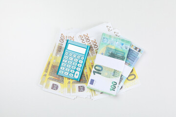 Euro money and calculator on white background, top view