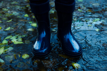 Person in rubber boots outdoor in rainy weather