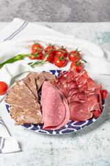 Cold Smoked Meat Plate, antipasto set platter. Roasted meat, salami and bacon on gray background