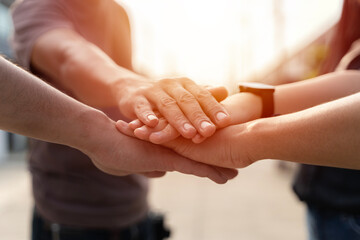 People joining hands in the middle.Successful multiracial businesspeople reach business goal feel...