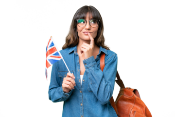Young caucasian woman holding an United Kingdom flag over isolated background having doubts while looking up