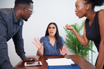 A mediator tries to keep the peace during argument, office boardroom. Divorce, arbitration