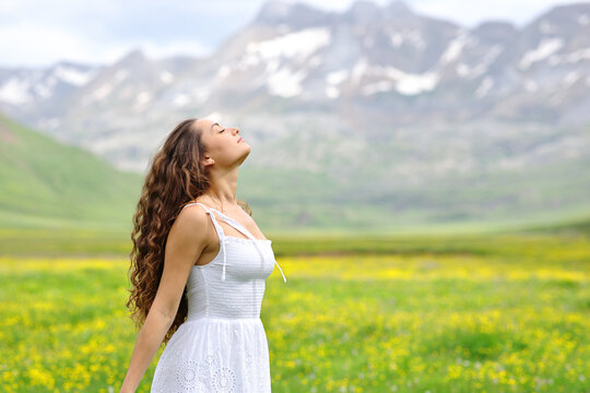 Woman in white dress breathing in a valley