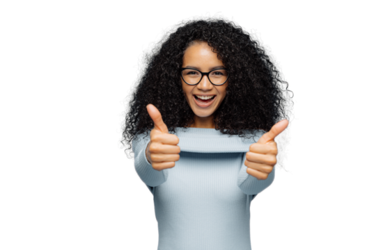 Happy lovely woman with bushy Afro hair gives thumb up, approves nice idea, wears fashionable sweater, isolated over blue background. Its fine, I agree. Body language concept. People and like concept