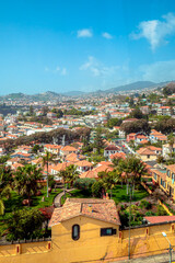 Fototapeta premium aerial view of Funchal city from cablecar - teleferico cabine on sunny winter day in february with a reflection in a window