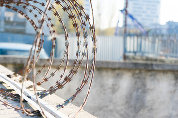 Barbered wire over a blue sky and on building ground, rusty