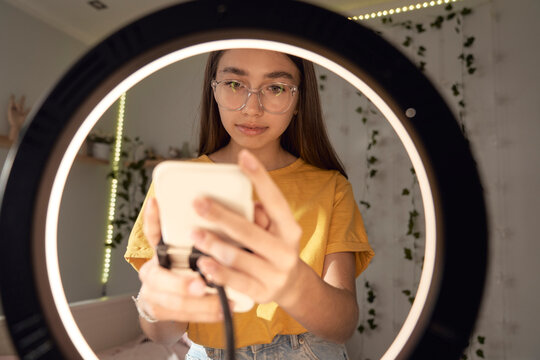 Teenage caucasian girl dancing and recording video using ring light