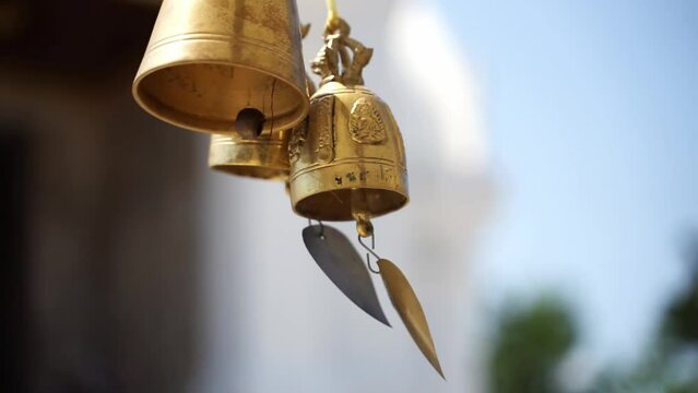 The wind blows the bell in front of the church