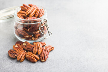 Peeled pecan nuts in jar on kitchen table.