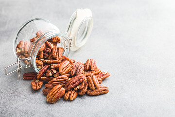 Peeled pecan nuts in jar on kitchen table.