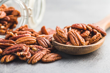 Peeled pecan nuts in wooden spoon.