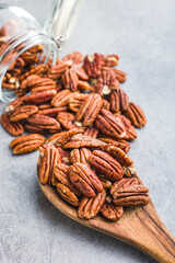 Peeled pecan nuts in wooden spoon.