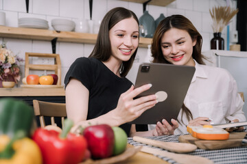Cooking woman using tablet computer.