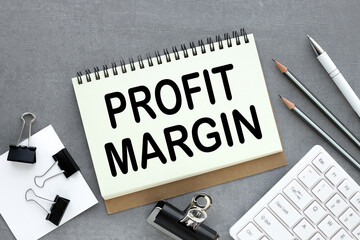 Business concept. gray background and white pencil. text on paper Profit Margins