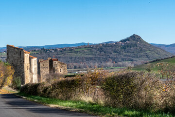 Fototapeta premium vieille bâtisse ensoleillée par une belle journée d'été avec en arrière plan le magnifique pic de Nonette sur un chemin de randonnée dans le puy de dôme