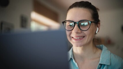 Portrait of a young adult caucasian woman wearing glasses taking a video call on a laptop. - Powered by Adobe