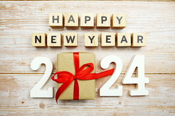 Happy New Year 2024 alphabet letters and gift box presents on wooden background
