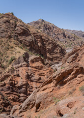 Vertical landscape view of spectacular orange red rocky valley between Shurobod pass and Panj valley, Khatlon, Tajikistan