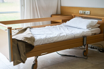 Blanket and pillow on empty bed in nursing home