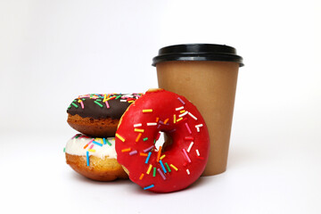 a paper craft cup with coffee or tea and donuts of different flavors on a white background