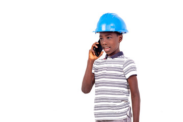 portrait of a young boy in a safety hat communicating on the cell phone.