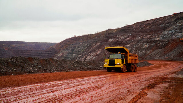 dump truck transporting iron ore in red iron ore quarry. The red quarry looks like the planet Mars