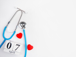 Stetascope with hearts on a light-coloured background with calendar. Concept of medicine,...