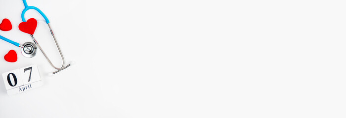 Stetascope with hearts on a light-coloured background with calendar. Concept of medicine, treatment, health. World Health Day.