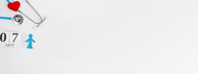 Stetascope with hearts on a light-coloured background with calendar and human figures. Concept of medicine, healing, health. World Health Day.