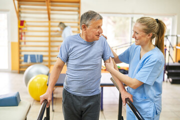 Physiotherapist assisting senior man in movement therapy