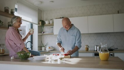 Happy senior couple cooking together at home. - Powered by Adobe