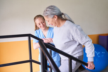 Caregiver assisting senior patient in movement therapy at nursing home