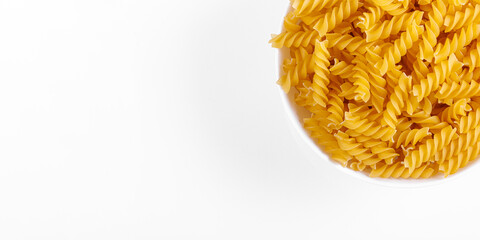 Pasta products in the form of a spiral on a plate, texture, on a white background