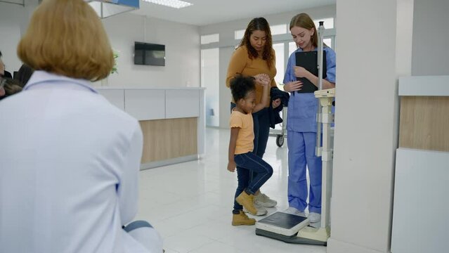 nurse takes a child to weigh and measure his height for a history in the hospital.
