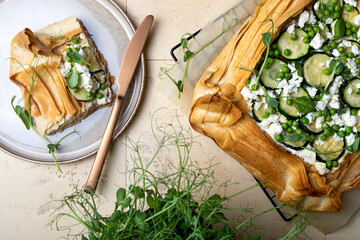 Zucchini and cheese phyllo dough tart with green peas, micro greens and basil. Zucchini and feta...