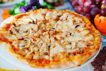 pizza with meat and mushrooms on the table. 