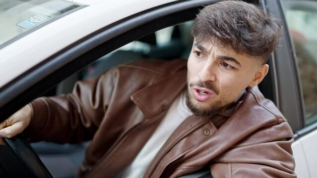 Young arab man driving car arguing at street