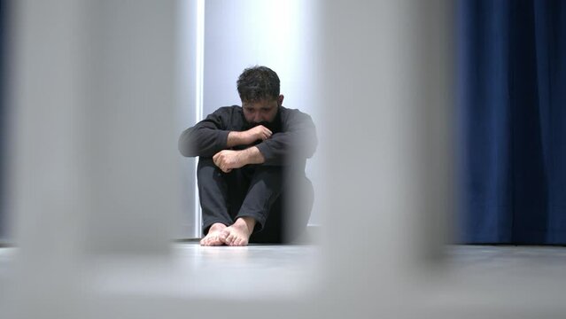 Man sitting alone felling sad worry or fear and hands up on head on black background
