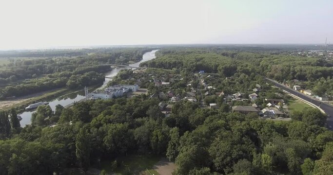 Drone flight, aerial view of the southern suburban part of Chernihiv, surrounded by dense forests, on the river Desna passenger pleasure boats