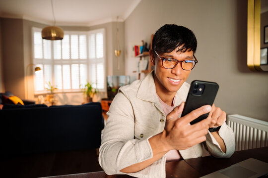 Asian male smiling and chatting on cellphone 