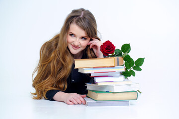 Studio shot of smiling schoolgirl doing her homework isolated over white background beautiful smart woman professor lies near books stack of large vintage books tome development focus banner 