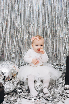 foil rain curtain for the photo zone. little girl and photo booth in silver style. mirror disco ball and silver confetti