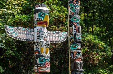 Native American Totem poles in Stanley Park, Vancouver. - obrazy, fototapety, plakaty