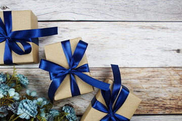 Gift boxes with blue ribbon on wooden background