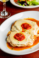 Chicken Parmesan or parmigiana. Italian comfort dish. Chicken breast covered in breadcrumbs fried, topped with marinara sauce, melted mozzarella, parmigiana and provolone cheeses and Italian parsley. 