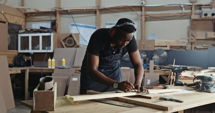 African carpenter very focused on his new wood work design. 
